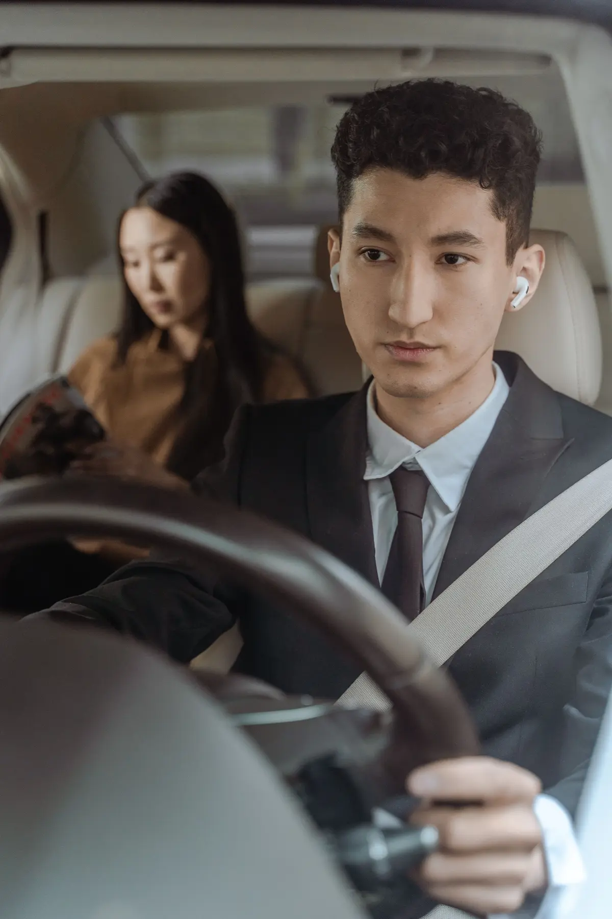 Professionally dressed driver transporting a passenger